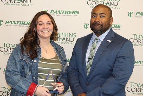 student holding award standing next to administrator