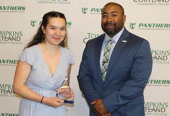 student holding award standing next to administrator