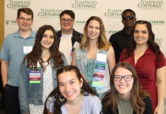 Group of students posing in front of backdrop