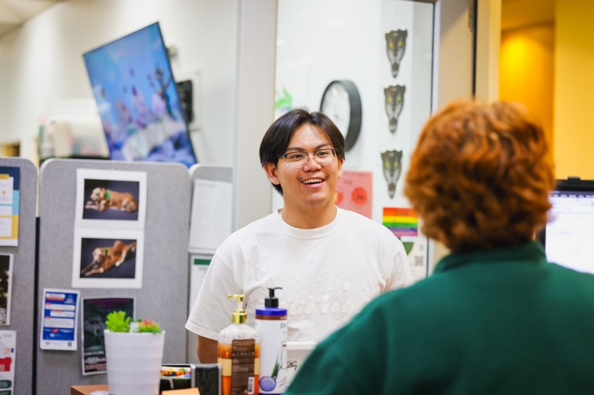 Student being greeted at the front desk of the Best Life Lounge